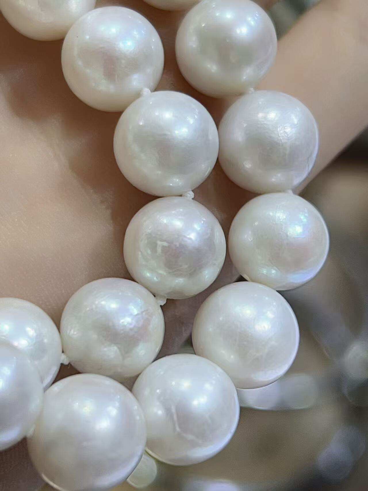 Lustrous white freshwater pearl beads for jewelry making, showing high surface reflection and near-round shape